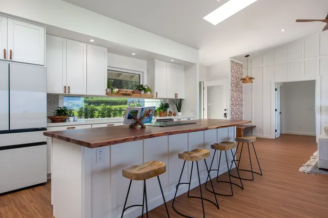 a kitchen with granite countertop a table chairs stove a sink and dishwasher