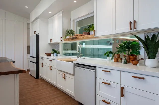 a kitchen with stainless steel appliances white cabinets and wooden floor