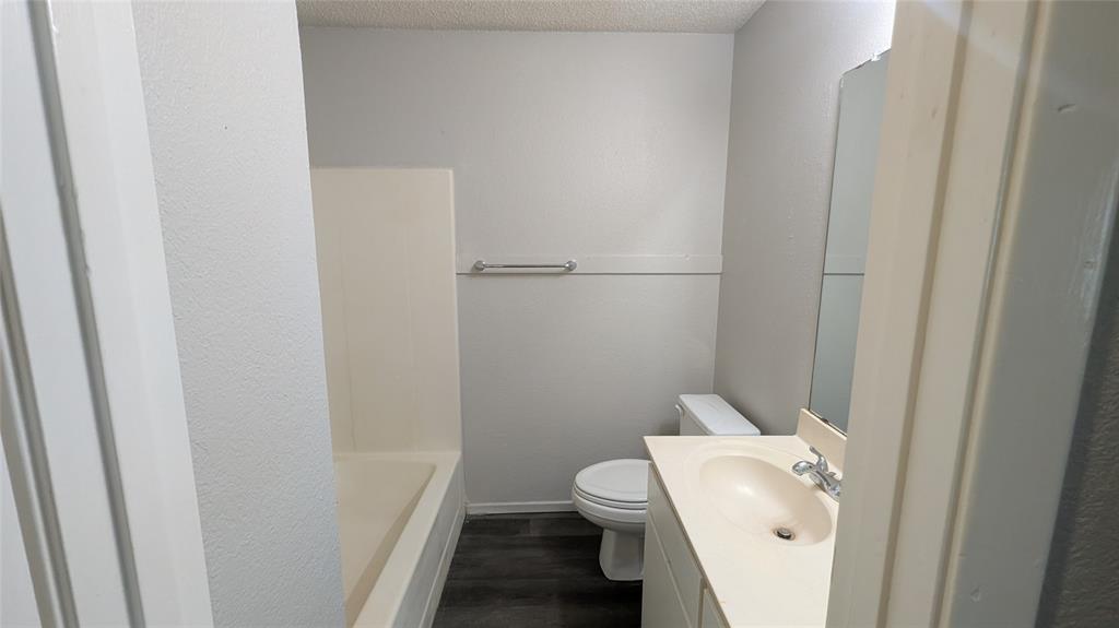 107 Beck Street, Unit B Florence, TX 76527 - Photo 6 of 8 Functional full bathroom with practical dark flooring and a bright vanity area.