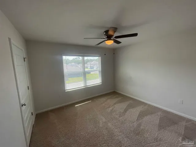 a view of room with a ceiling fan and window