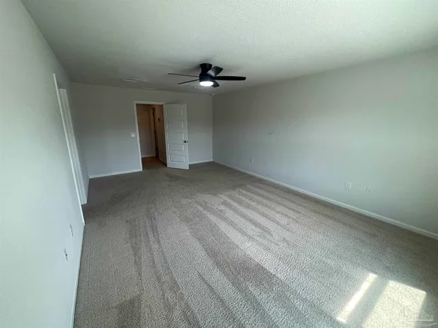an empty room with a ceiling fan and a window