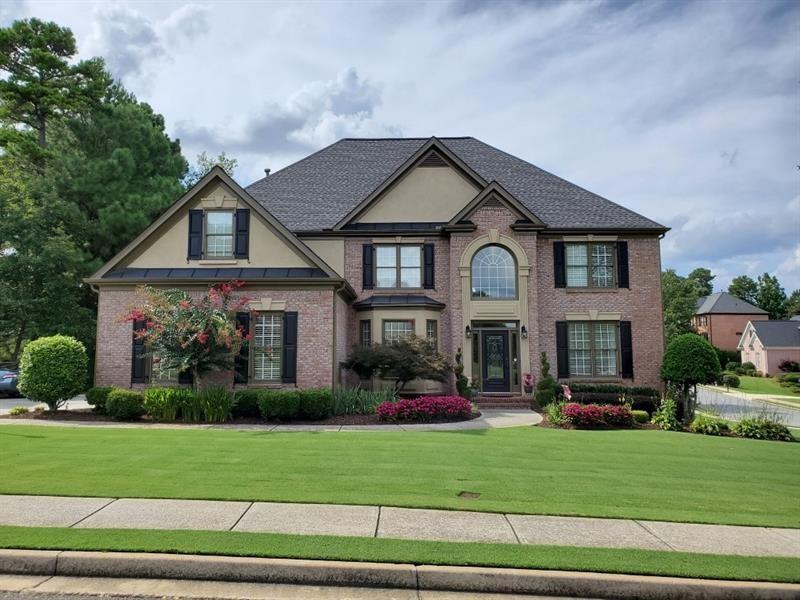 a front view of a house with a garden and plants