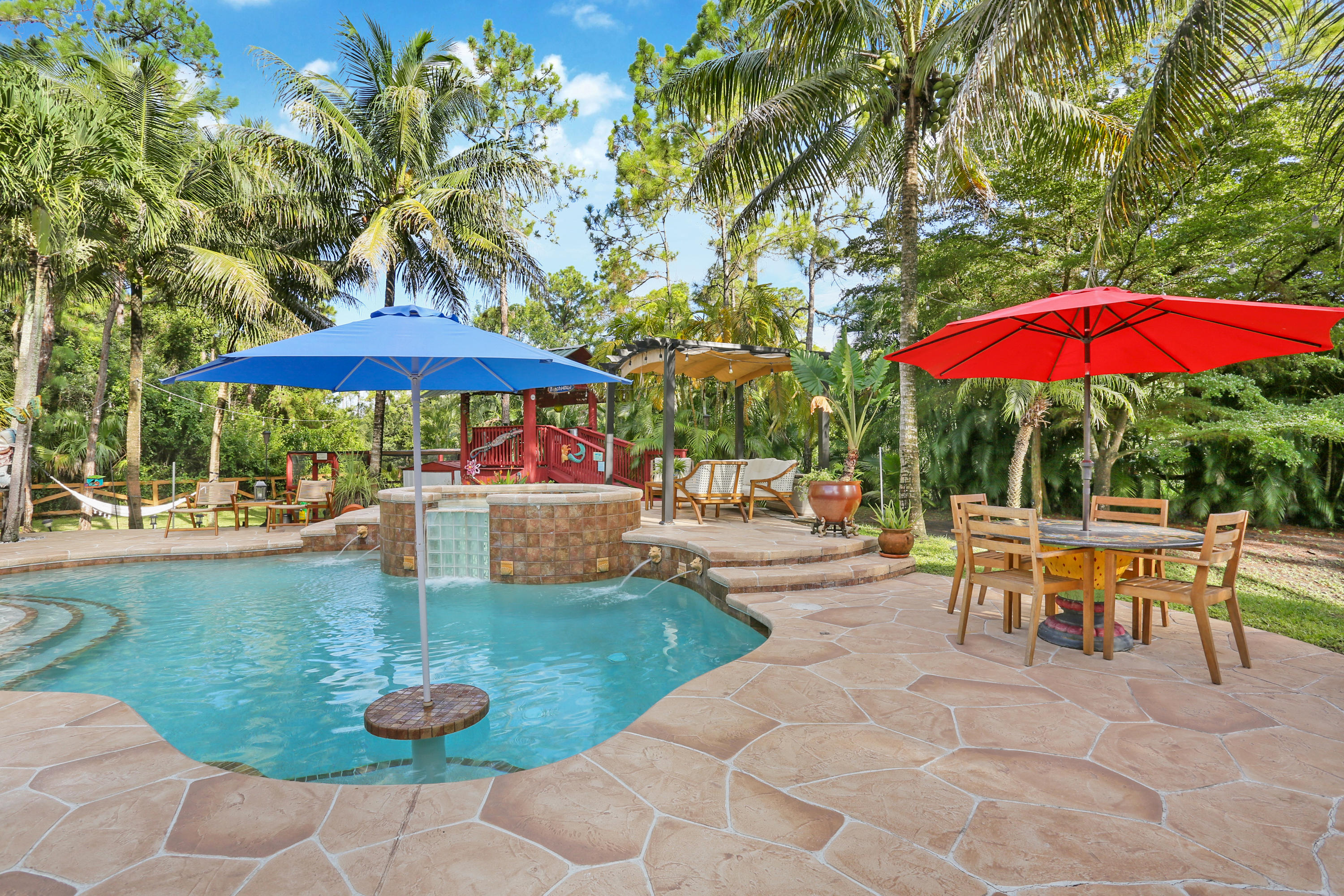 18604 43rd Road North Loxahatchee, FL 33470 - Photo 13 of 40 a view of a patio with chairs and table under an umbrella