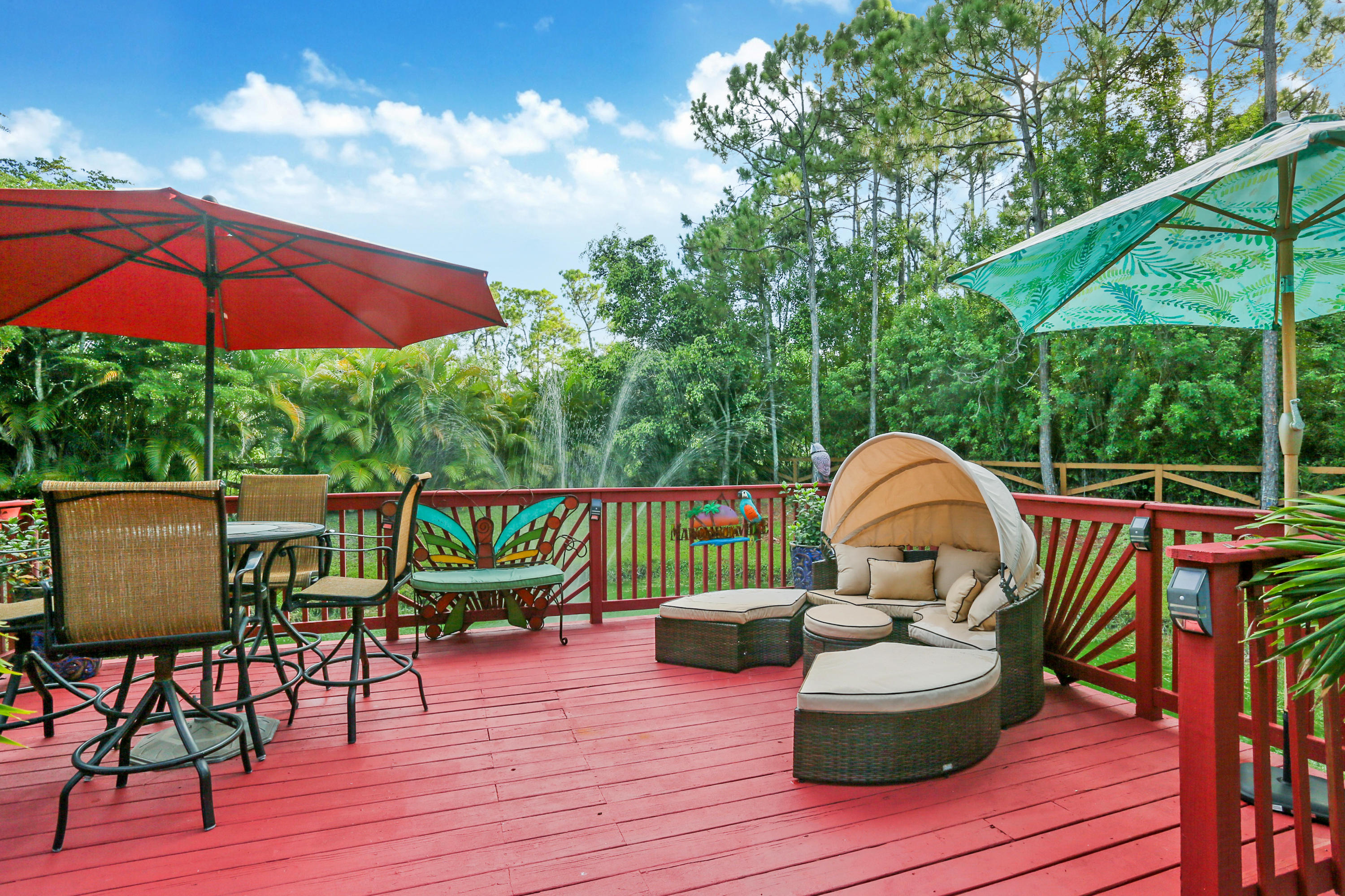 18604 43rd Road North Loxahatchee, FL 33470 - Photo 18 of 40 a view of deck with table and chairs under an umbrella with wooden floor