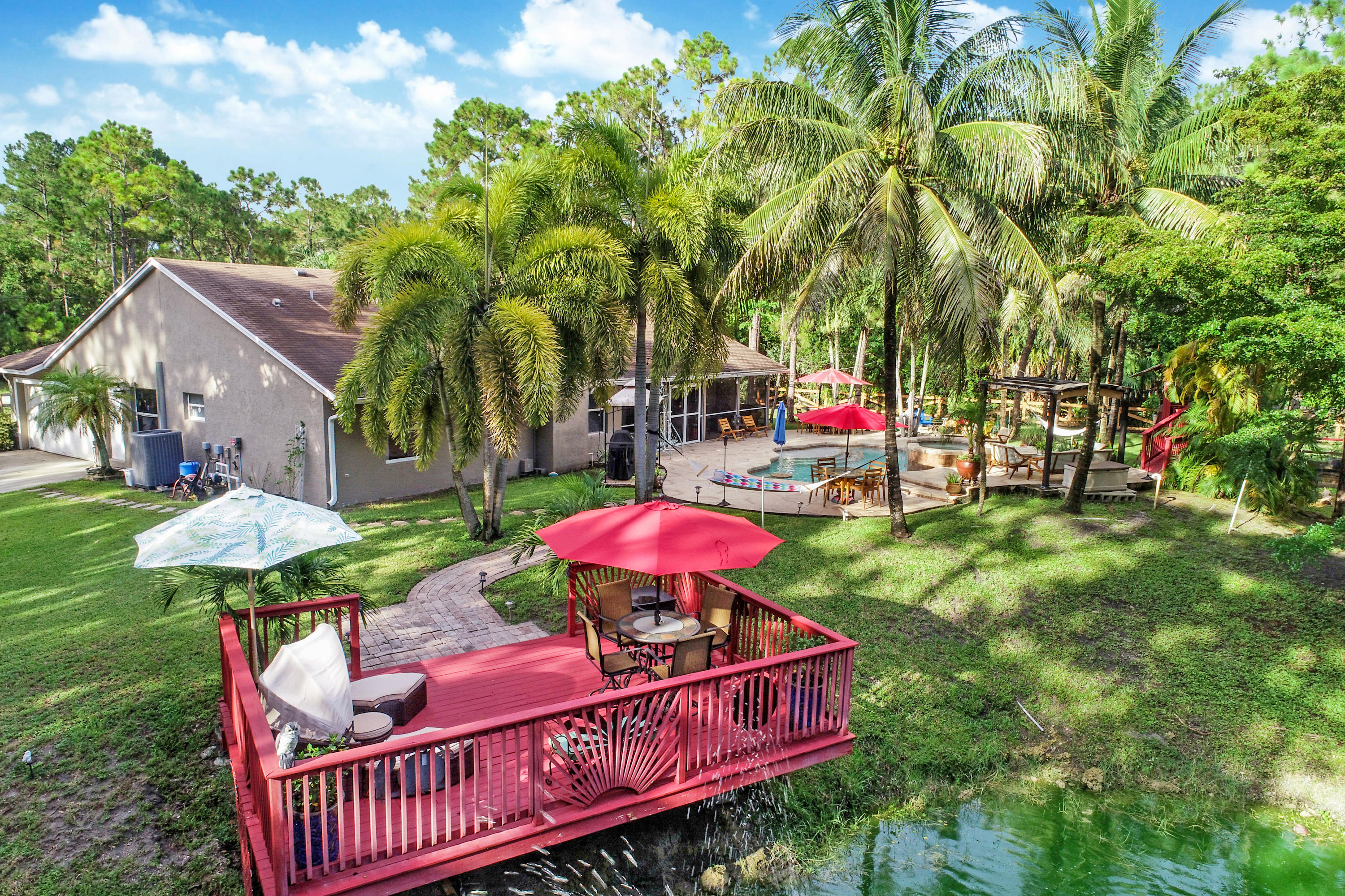 18604 43rd Road North Loxahatchee, FL 33470 - Photo 3 of 40 a view of a house with table and chairs under an umbrella