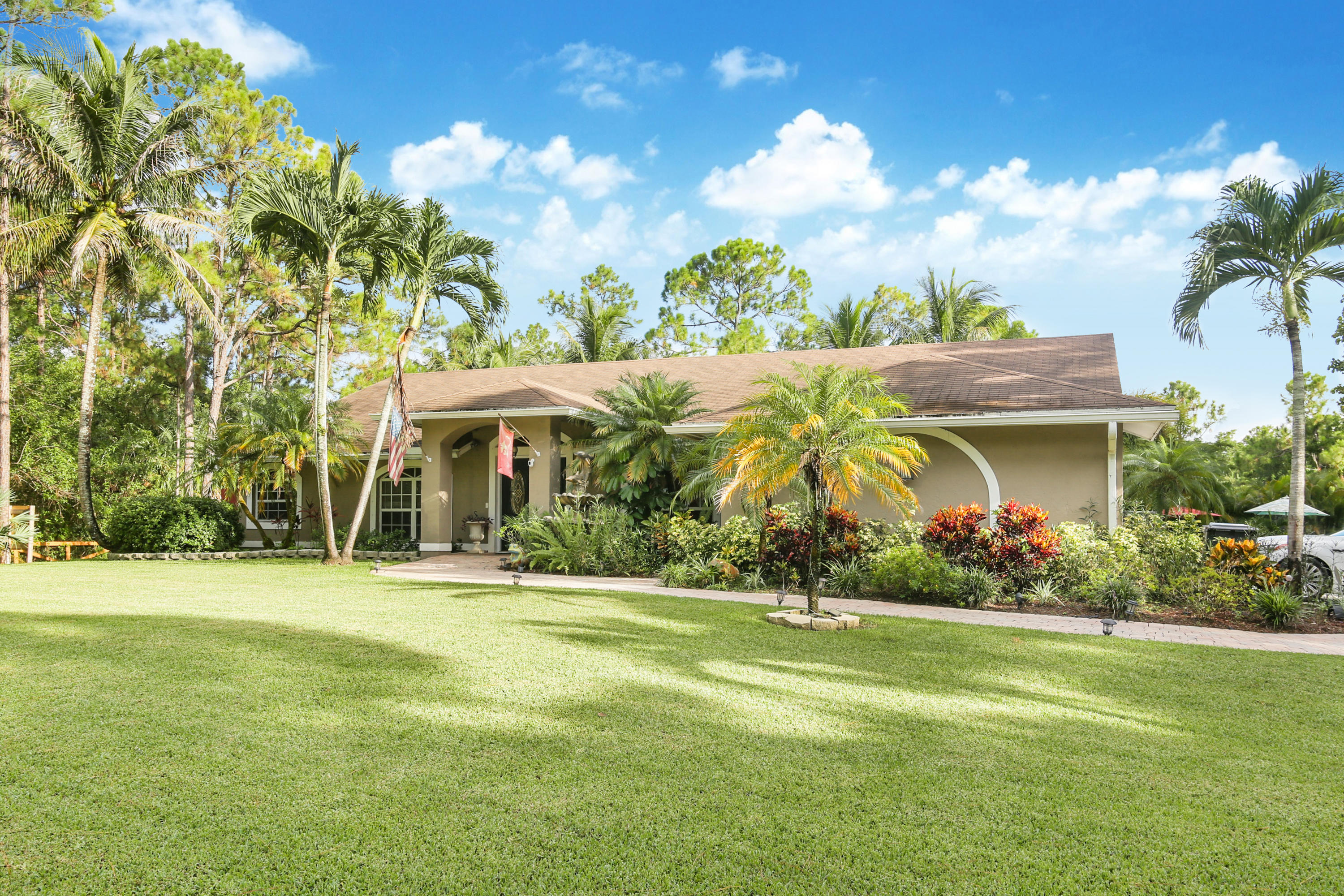 18604 43rd Road North Loxahatchee, FL 33470 - Photo 6 of 40 a front view of a house with a yard