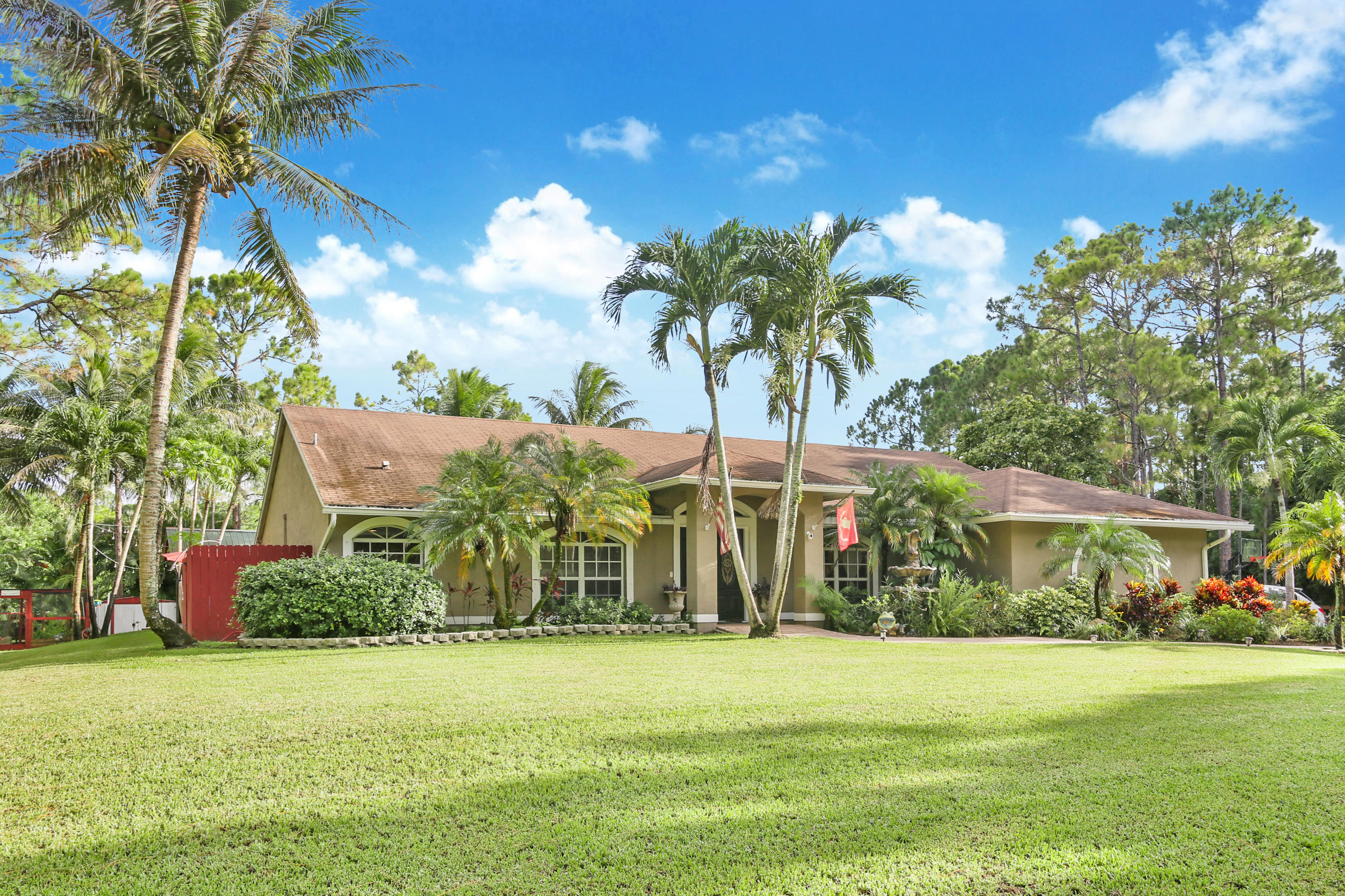 18604 43rd Road North Loxahatchee, FL 33470 - Photo 7 of 40 a front view of a house with a garden