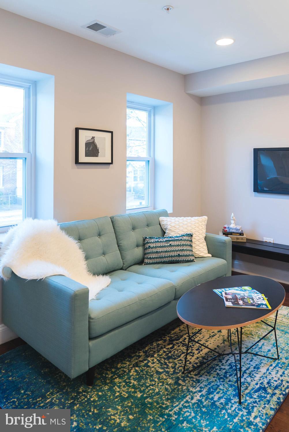 1823 D Street Northeast, Unit B Washington, DC 20002 - Photo 2 of 27 a living room with furniture a rug and a flat screen tv