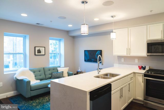 a kitchen that has a sink a stove and chairs