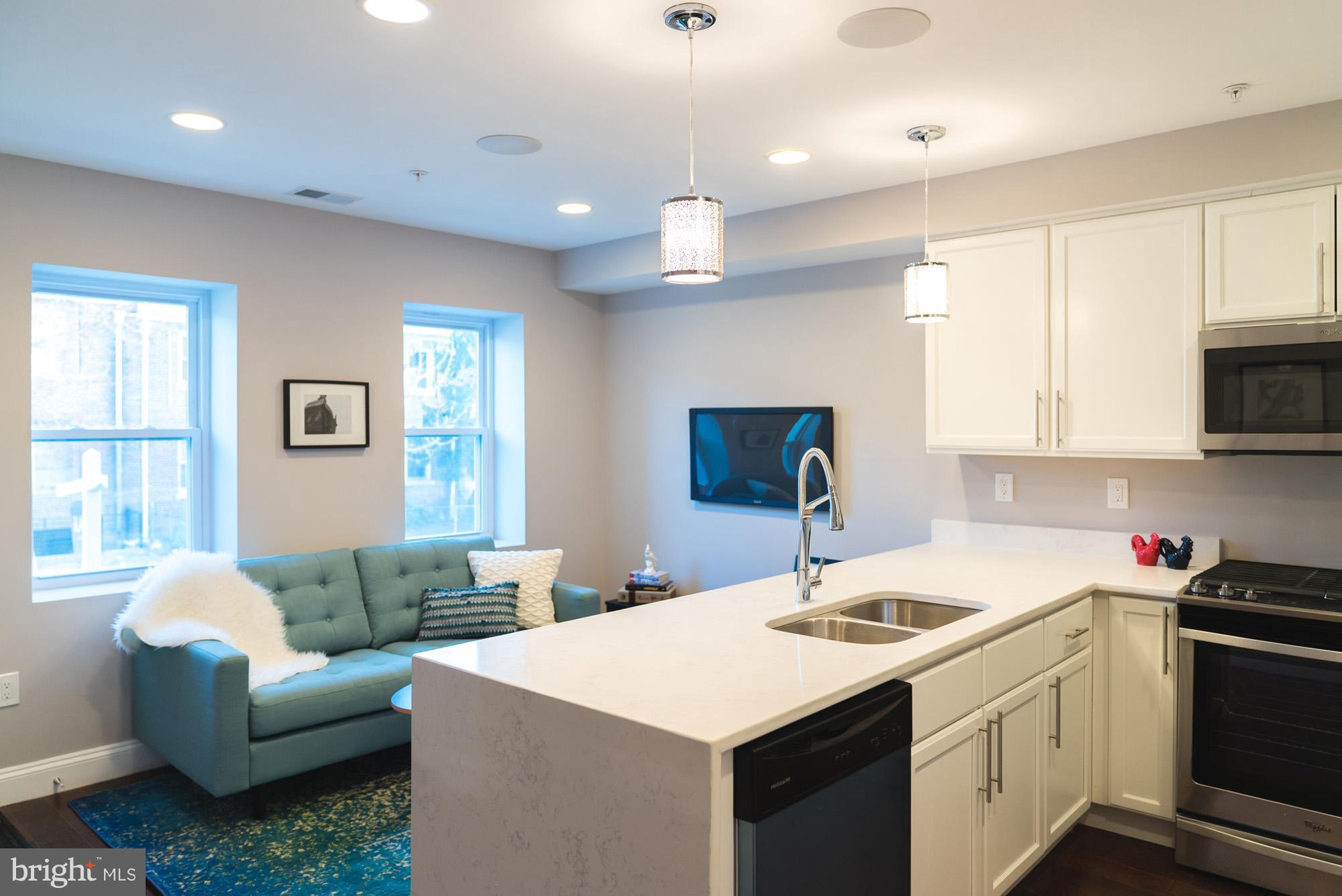 1823 D Street Northeast, Unit B Washington, DC 20002 - Photo 5 of 27 a kitchen that has a sink a stove and chairs