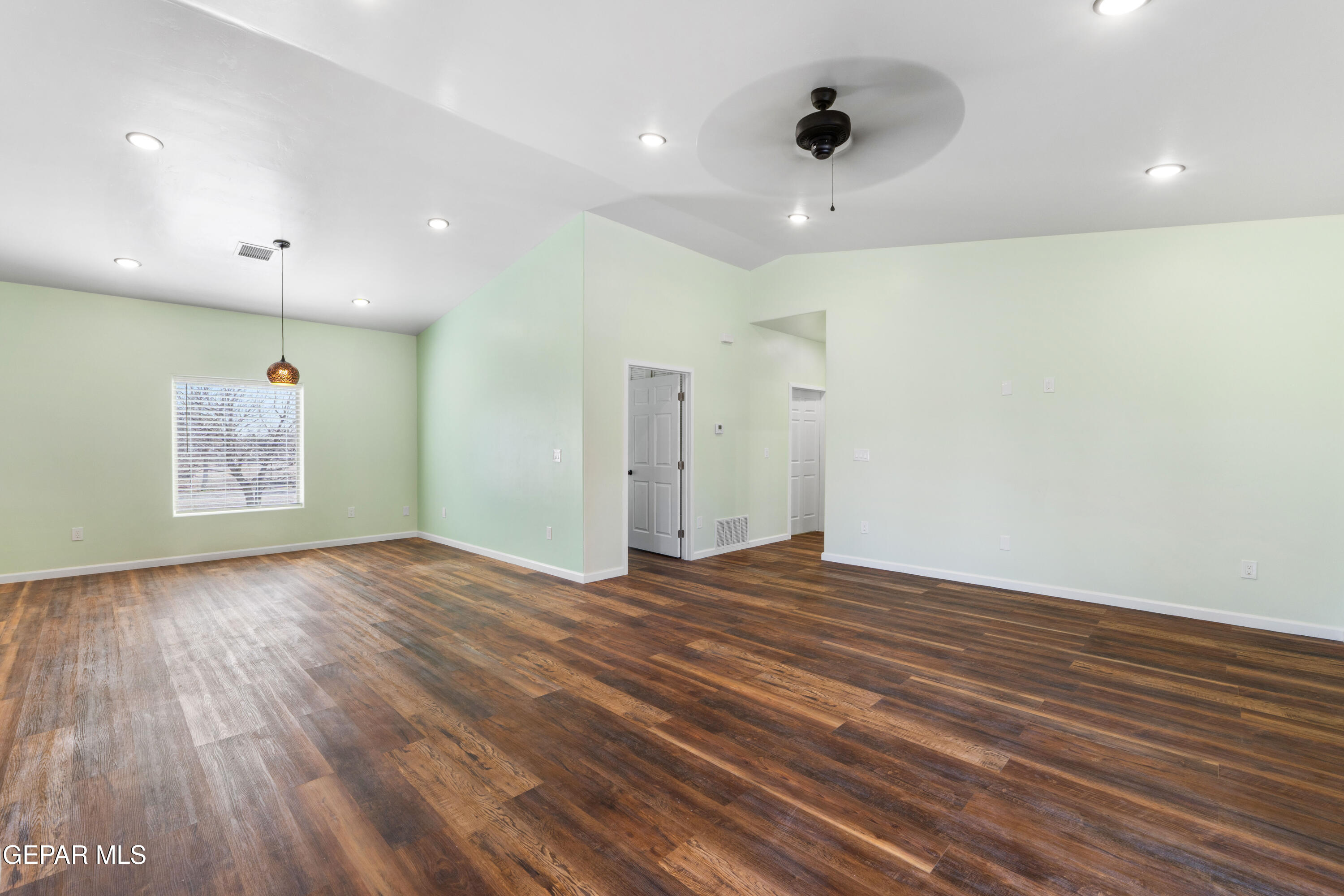 646 Snow Road, Unit 2 Las Cruces, NM 88005 - Photo 10 of 41 a view of an empty room with wooden floor and a ceiling fan