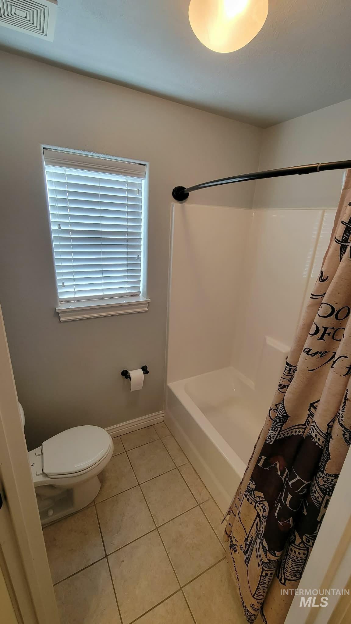 470 Sunflower Road Rexburg, ID 83440 - Photo 11 of 16 Full bathroom with light tile patterned floors and shower / tub combo with curtain