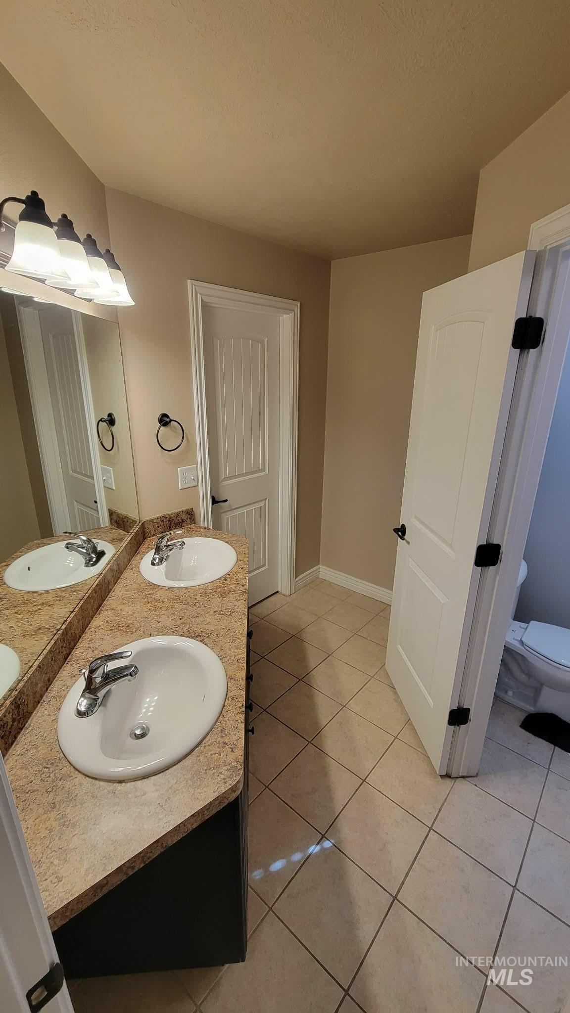 470 Sunflower Road Rexburg, ID 83440 - Photo 12 of 16 Bathroom with double vanity and light tile patterned floors