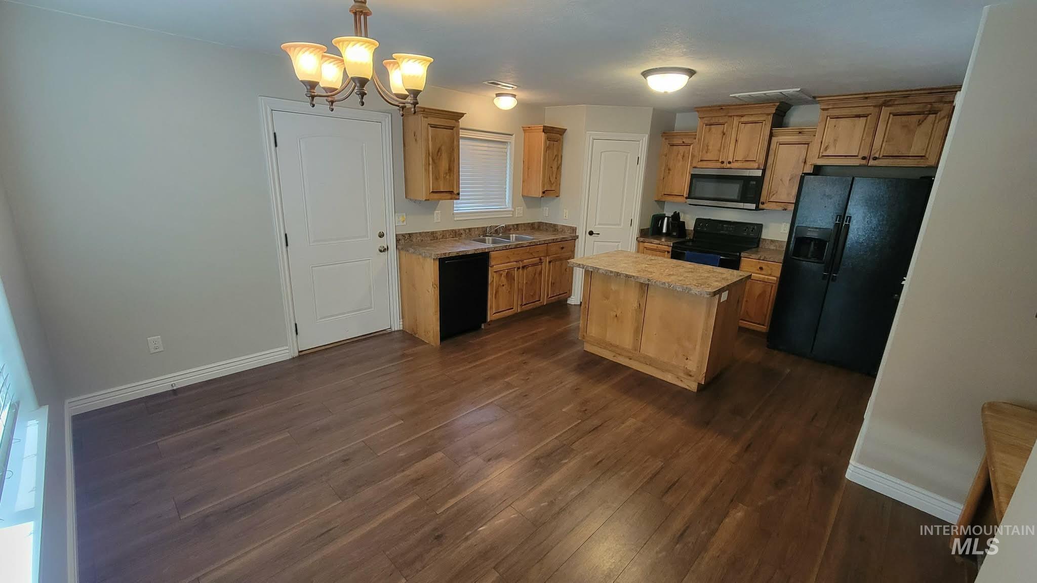 470 Sunflower Road Rexburg, ID 83440 - Photo 5 of 16 Kitchen featuring black appliances, suspended lighting, dark wood-type flooring, light countertops, and a center island