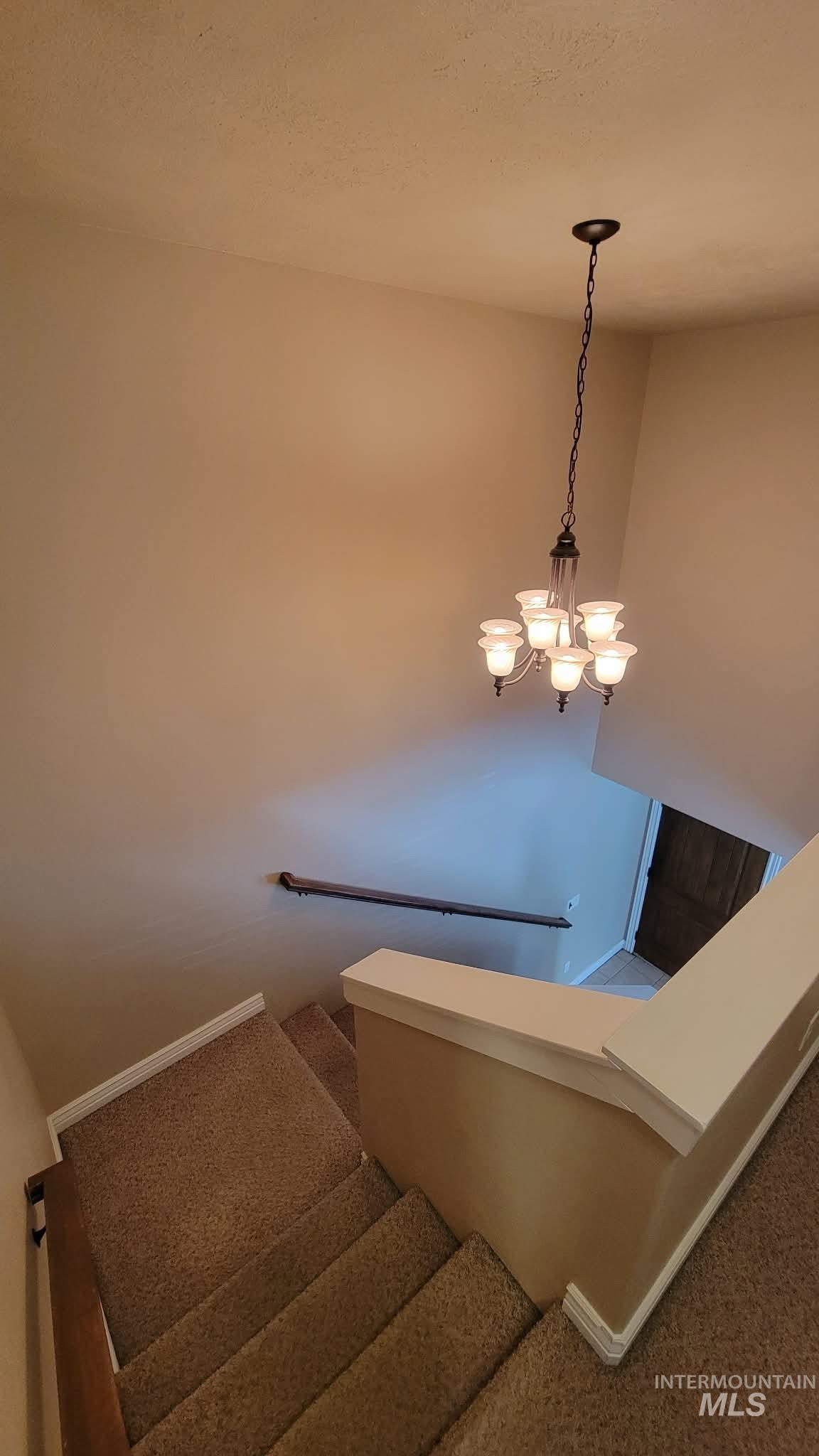 470 Sunflower Road Rexburg, ID 83440 - Photo 8 of 16 Stairs with suspended lighting and carpet