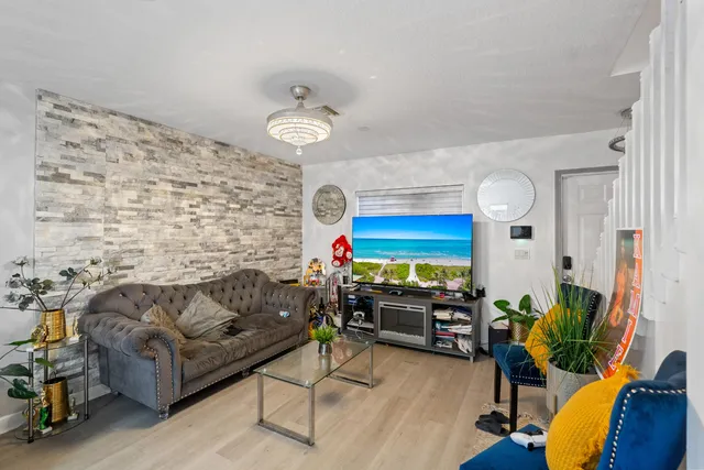 a living room with furniture kitchen view and a large window