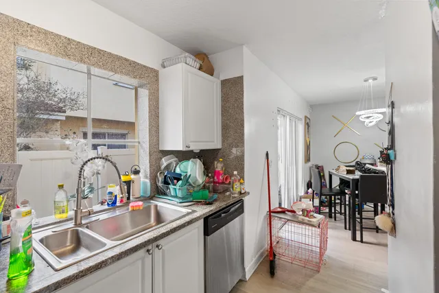a kitchen with granite countertop a sink stainless steel appliances and cabinets