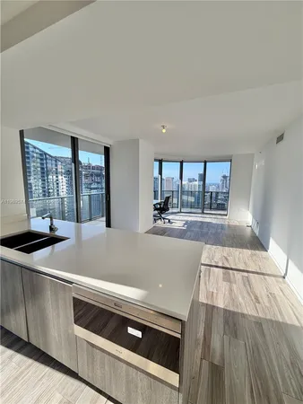 a living room with stainless steel appliances kitchen island a large counter space and a view of kitchen