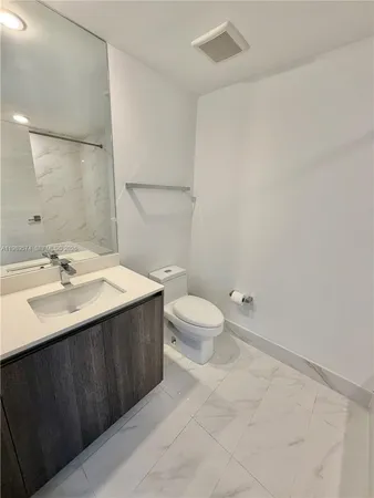 a bathroom with a sink a toilet and a large mirror