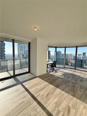 a view of a living room kitchen and an empty room