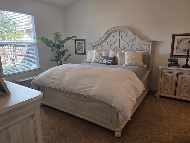 a bedroom with a bed next to a window with outer view