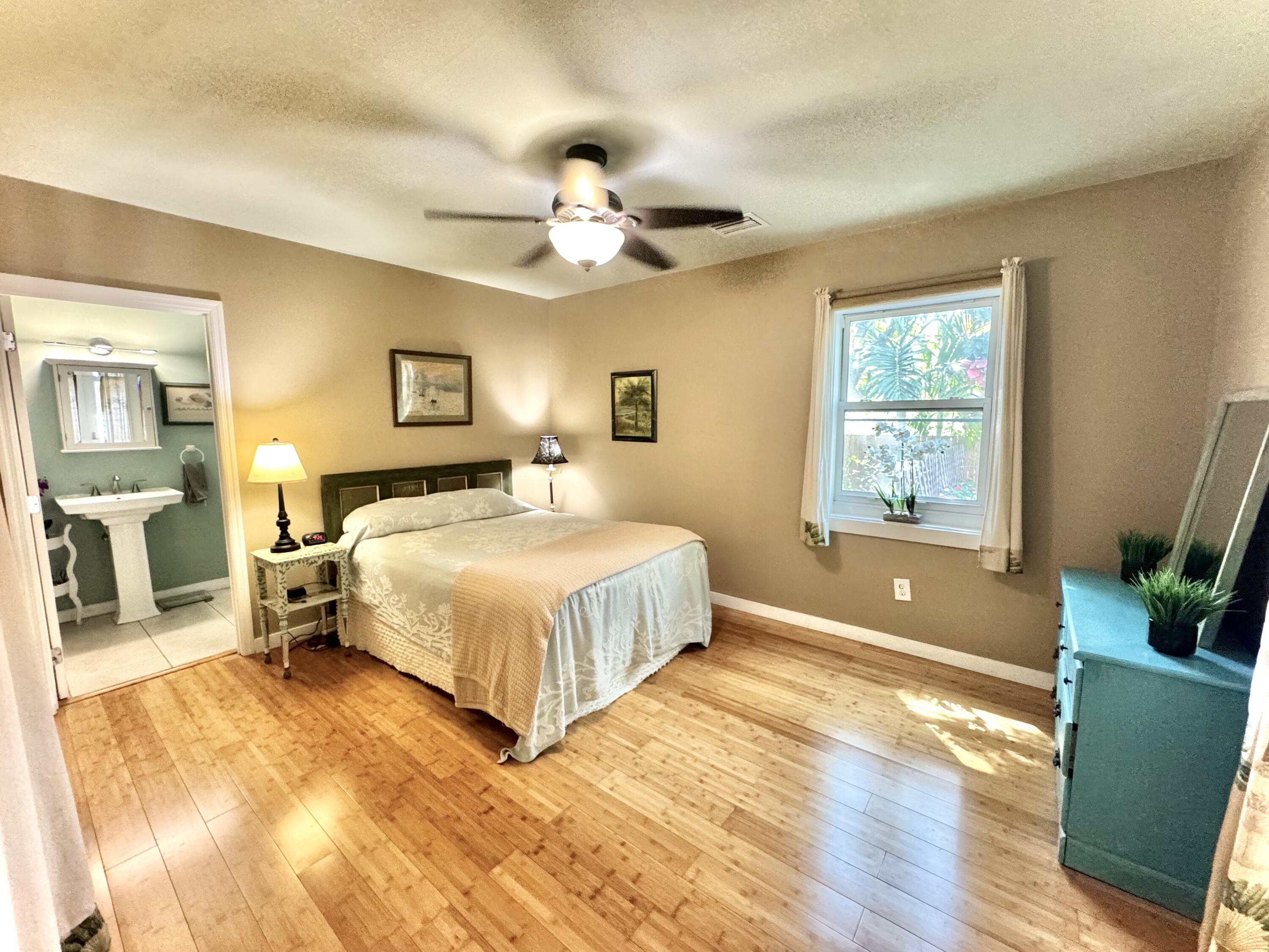 322 Southard Street Key West, FL 33040 - Photo 16 of 35 a bedroom with a large bed and a chandelier