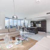 a living room with furniture and view of kitchen