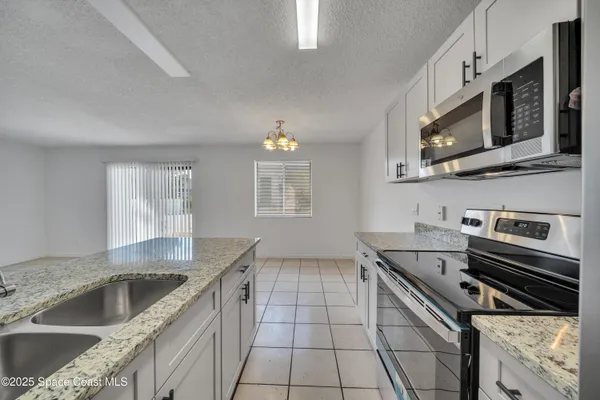 a kitchen with stainless steel appliances granite countertop a sink and a stove