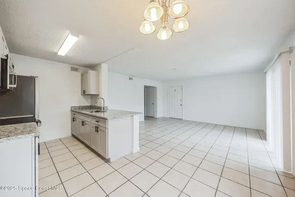 a kitchen with granite countertop white cabinets and stainless steel appliances