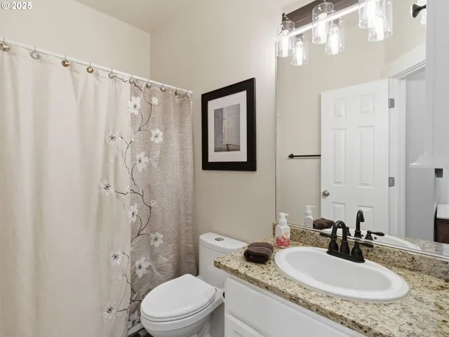 a bathroom with a granite countertop sink toilet and shower