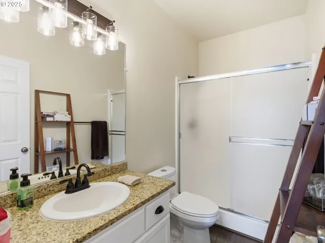 a bathroom with a granite countertop sink toilet and shower