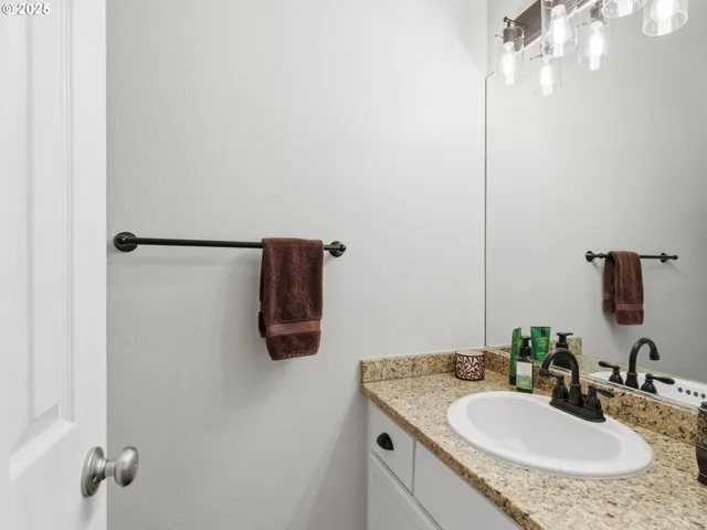 a bathroom with a granite countertop sink and a mirror