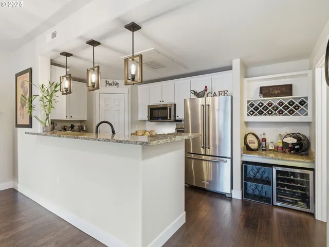 a kitchen with stainless steel appliances granite countertop a refrigerator and a stove top oven