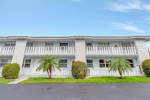 a view of a house with a patio and a yard