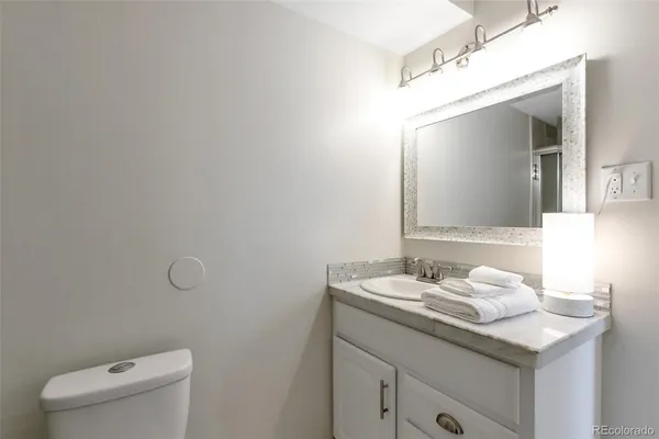 a bathroom with a granite countertop sink and a mirror