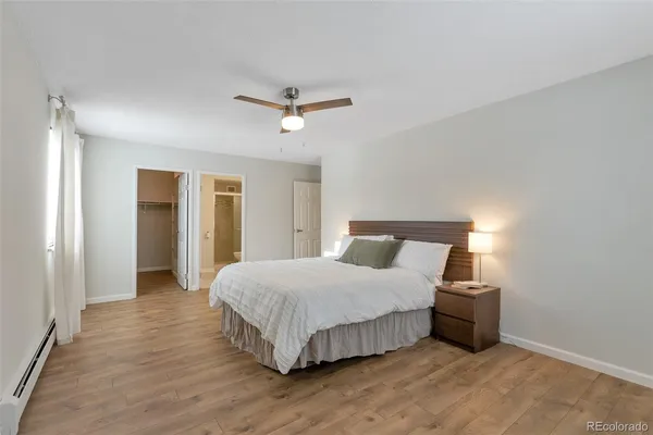 a bedroom with a large bed and ceiling fan