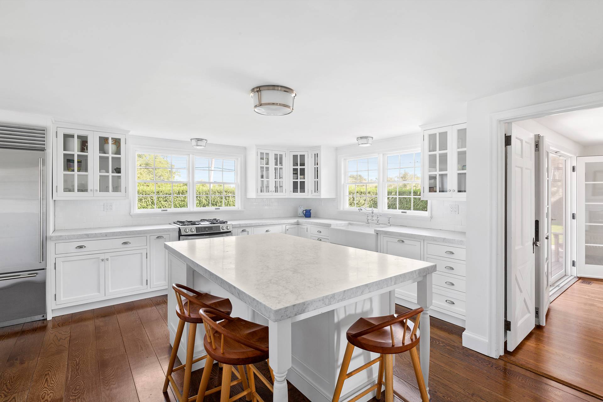 406 Hayground Road Water Mill, NY 11976 - Photo 2 of 20 a kitchen with stainless steel appliances granite countertop a stove a refrigerator a sink a dining table and chairs with wooden floor