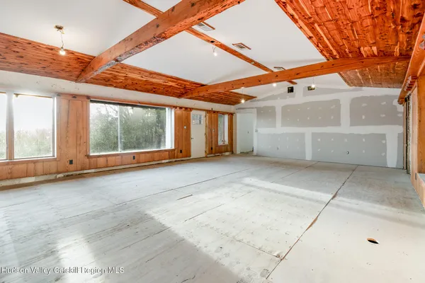 a view of an empty room with a fireplace and windows
