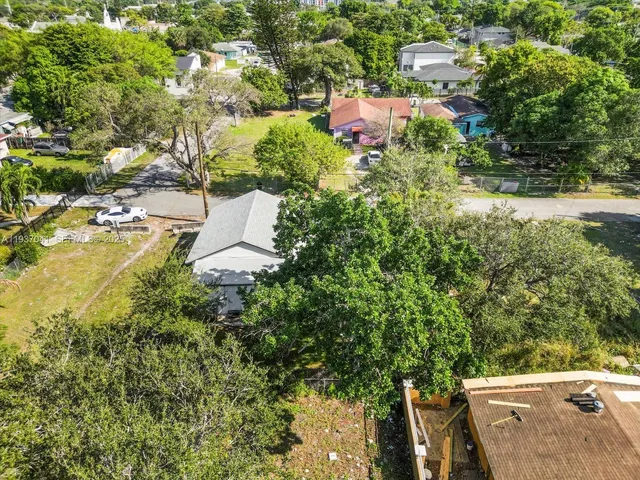 an aerial view of residential house with outdoor space and trees all around