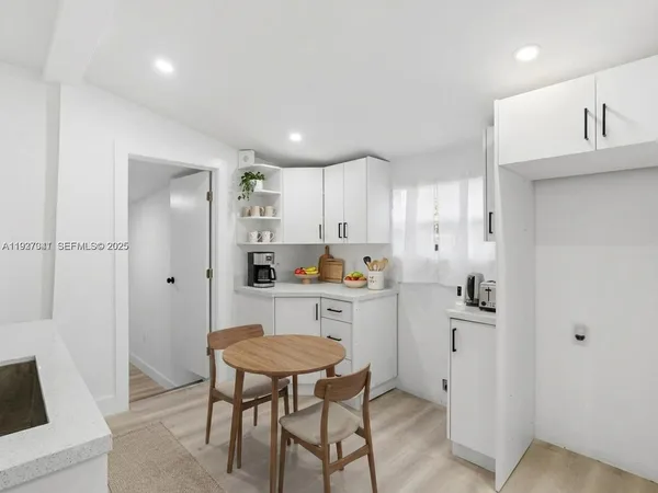 a kitchen with white cabinets and stainless steel appliances