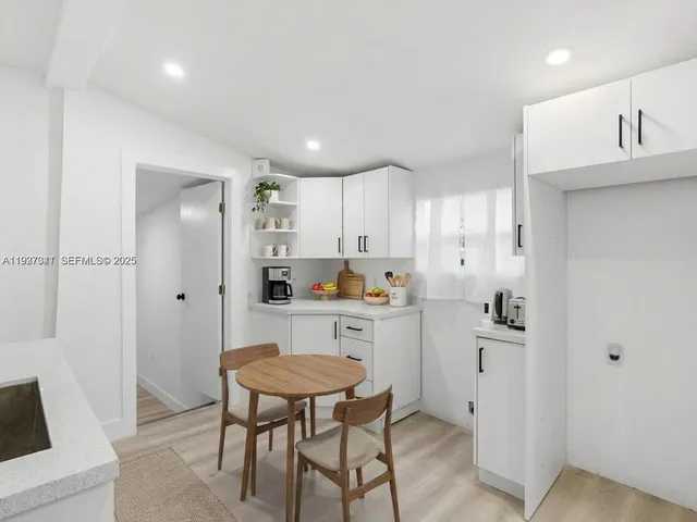 a kitchen with white cabinets and stainless steel appliances