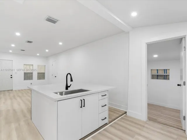a view of an empty room with wooden floor and closet