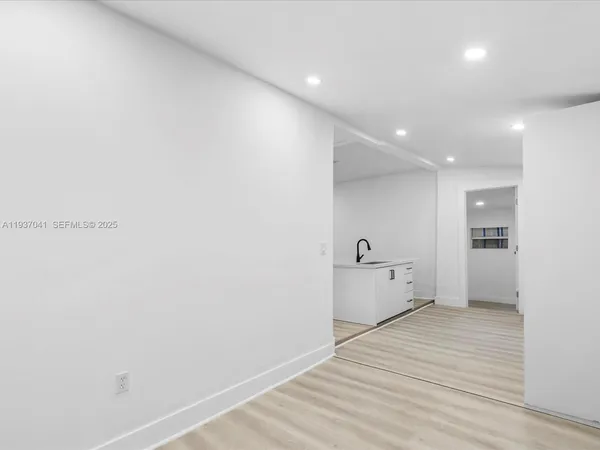 a kitchen with a refrigerator and white cabinets