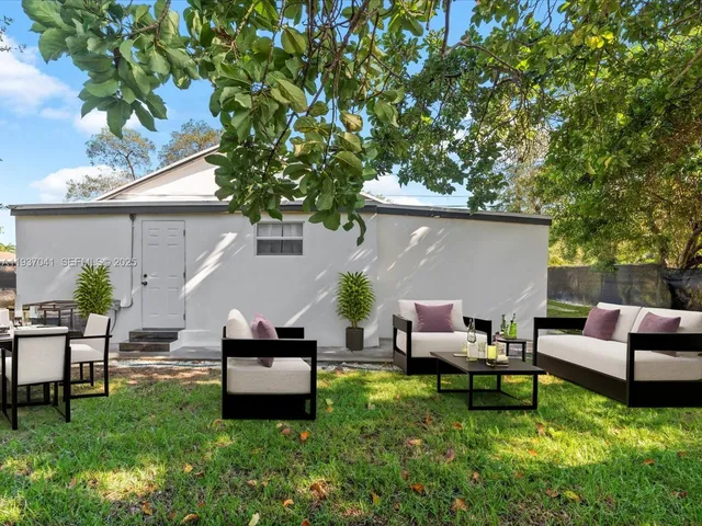 a backyard of a house with table and chairs