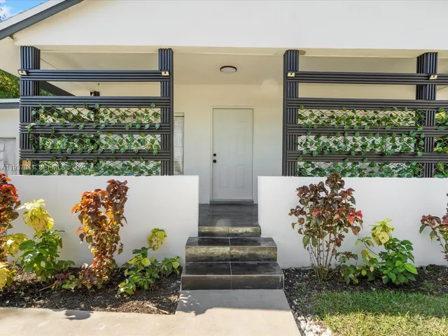 a living room with large windows and a table
