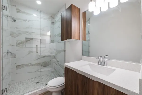 a bathroom with a sink a toilet and shower