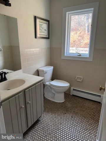 a bathroom with a sink toilet and window