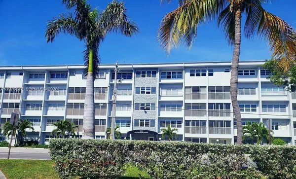 a front view of multiple houses with a garden
