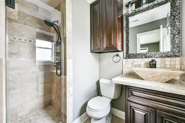 a bathroom with a granite countertop sink toilet and shower