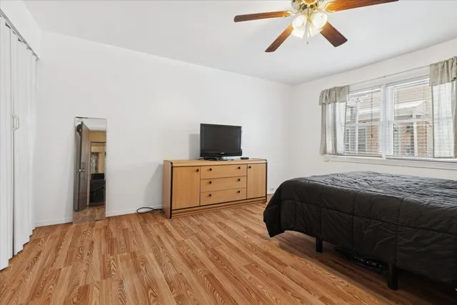 a bedroom with a bed and a flat tv screen on dresser